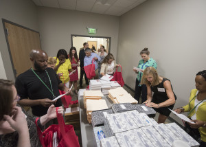 Volunteers and corps members work together to assemble classroom kits of school supplies.